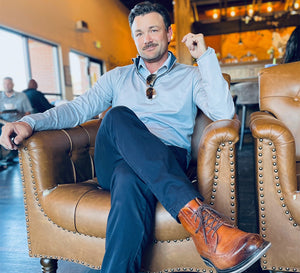 Influencer sitting on coffee shop sofa in MAELREG Pinstripe Quarter Zip Pullover, exuding business style.