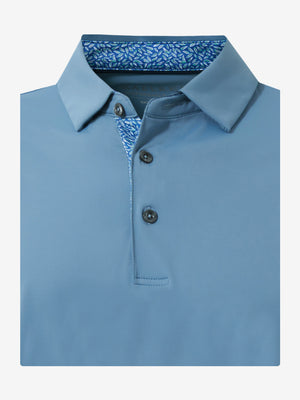 Flat lay of the folded misty blue everyday classic solid polo, showcasing the neat silhouette and solid color design