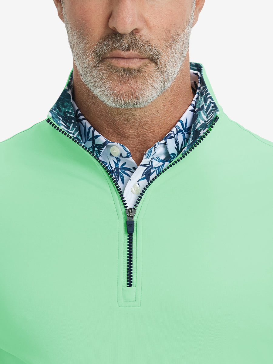 Close-up from nose to chest, showing collar and zipper detail of the light green golf pullover.