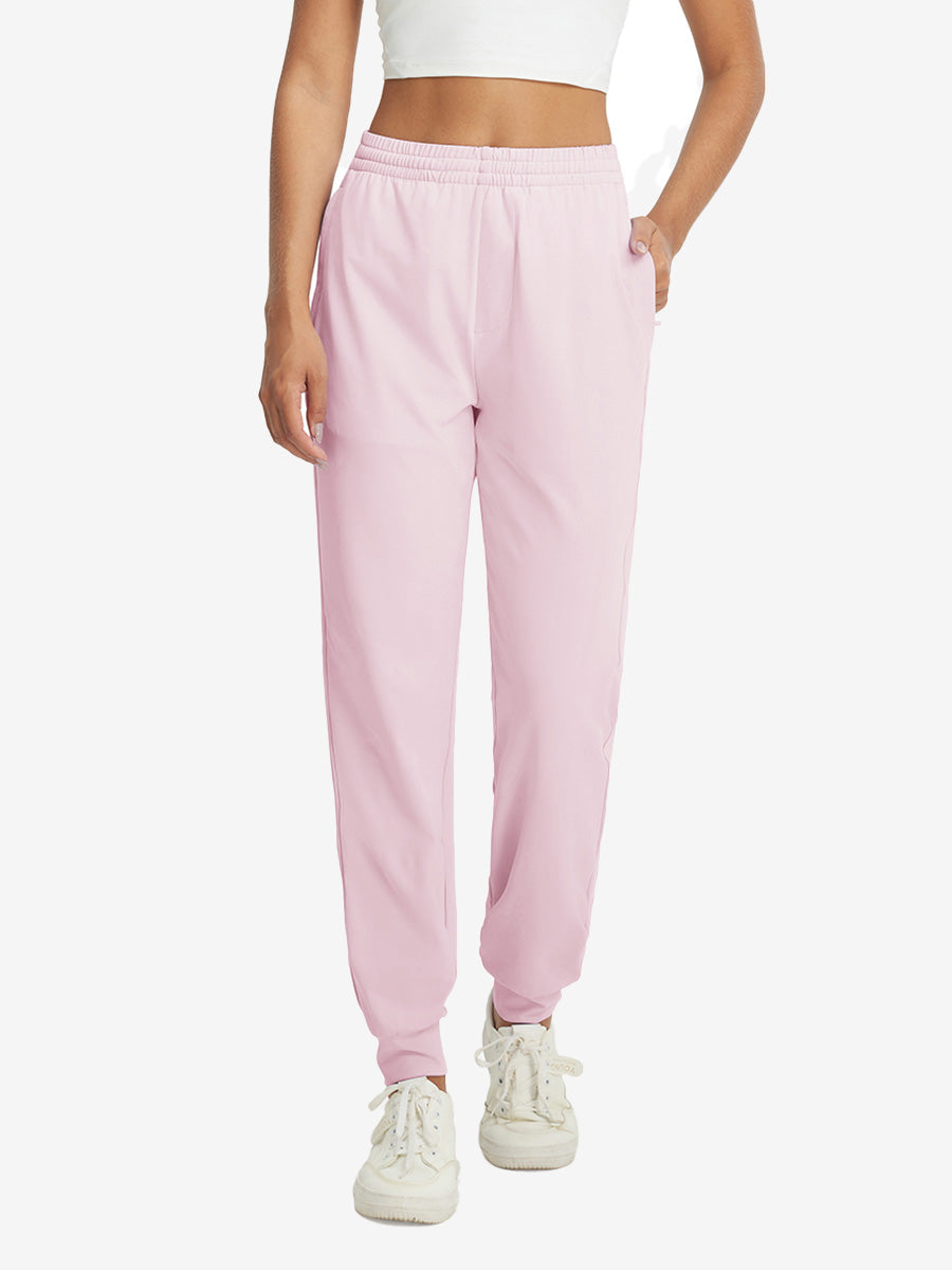 Model with hand in pocket wearing lightweight women's stretchy joggers sweatpants in light purple.