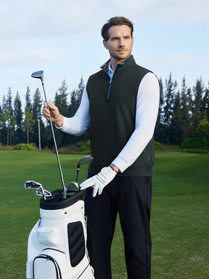 Model placing a golf club into a golf bag on course, styled in print collar quarter zip golf vest with dark grey