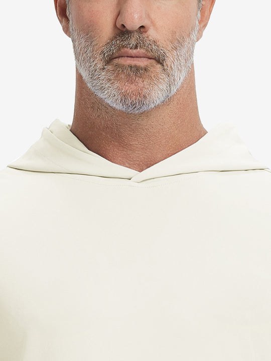 Close-up from nose to chest, showing soft collar texture and stitching detail of the cream hoodie.
