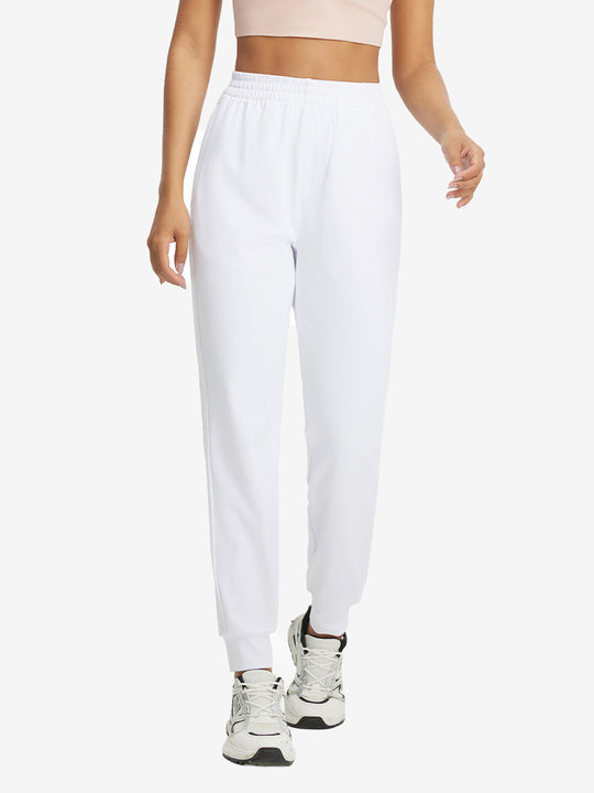 Model with hand in pocket wearing lightweight women's stretchy joggers sweatpants in white.