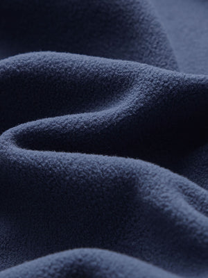 Close-up fabric detail of golf fleece winter puffer jackets, quilted texture and warm feel in navy