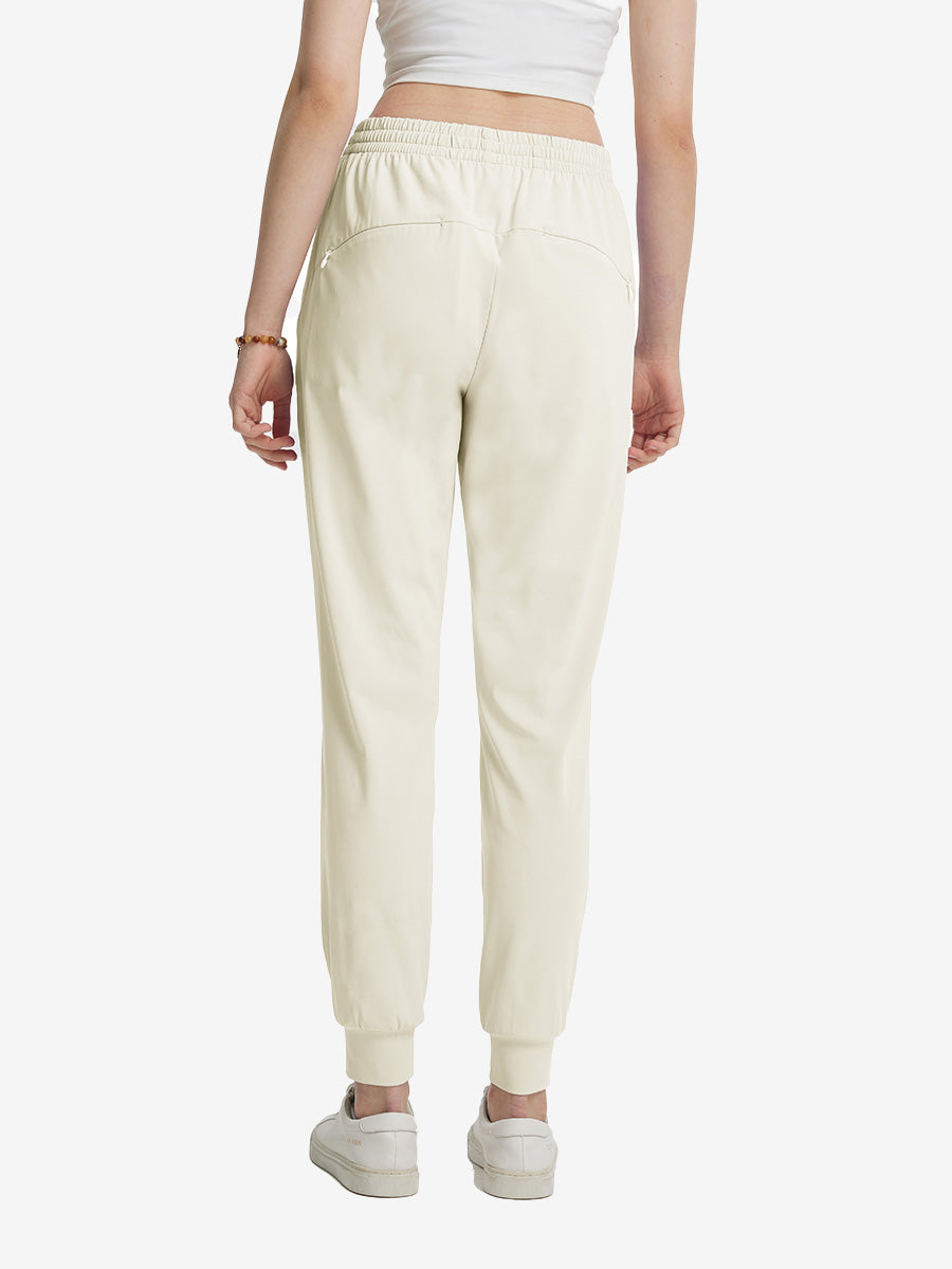 Back view of lightweight women's stretchy joggers sweatpants on model, shown in cream.