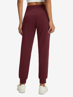 Model wearing women's stretch fleece lined water resistant joggers in wine, showing the back lower body view.