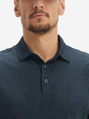 Front view from nose to chest of model wearing navy coconut tree breathable jacquard pattern 3-button golf polo