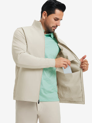 Model wearing water-resistant zip up golf jacket, light khaki, front upper-body with one hand in pocket.