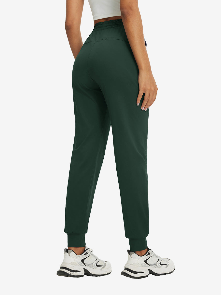 Back view of lightweight women's stretchy joggers sweatpants on model, shown in forest green.