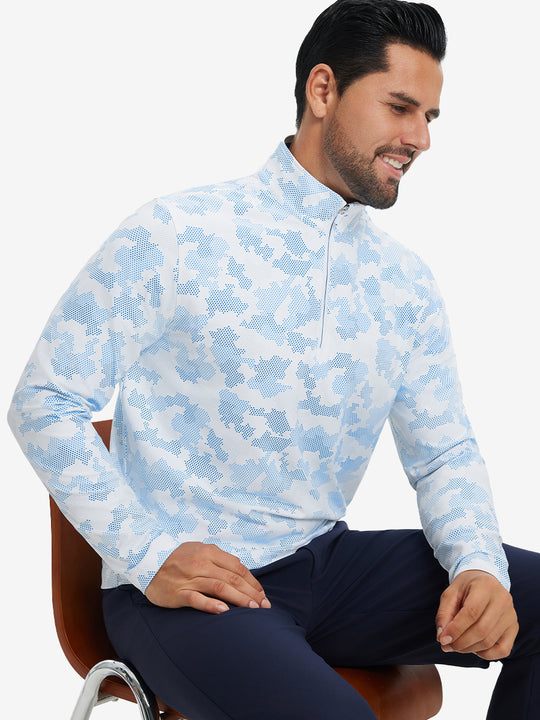 Model seated on chair, wearing full print quarter zip pullover in sky blue camo, casual upper body view.