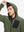 Model wearing hood and pulling it slightly, dressed in full zip fleece hoodied jacket in green.