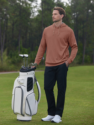Full body model on golf course wearing classic heather pullover hoodies with 2 pocket, brick melange