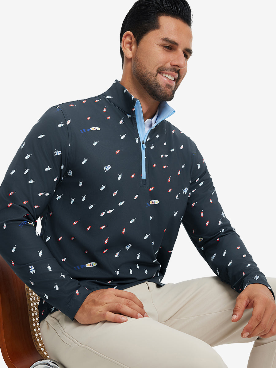 Model seated on chair, wearing full print quarter zip pullover in ocean yacht, casual upper body view.