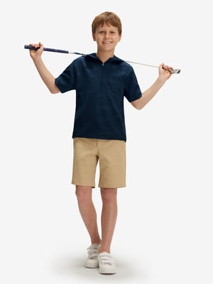 Full-body shot of model holding a golf club in navy water-resistant short sleeve q-zip hoodie for boys