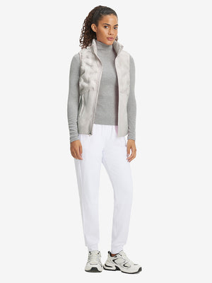 Model holding golf club full body, women's lightweight slim-fit puffer vest styled in sporty oyster grey