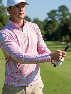 Model swinging on golf course wearing full print lightweight quarter zip pullover in pink artichoke