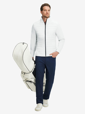 Front full body shot of model wearing white warm puffer winter golf jacket and holding a golf bag