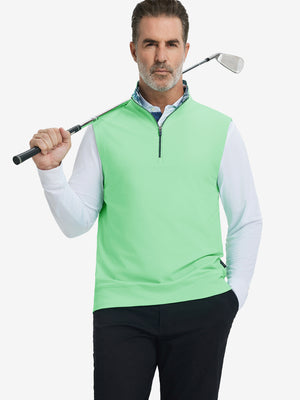 Model holding golf club, wearing print collar quarter zip golf vest in dark grey, upper body view.