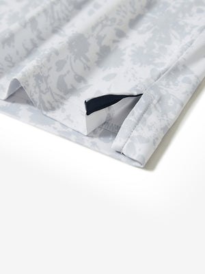 Hem slit detail of the gray ink splash lightweight print long sleeve polo, showing fine stitching and finish.