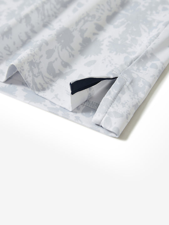 Hem slit detail of the gray ink splash lightweight print long sleeve polo, showing fine stitching and finish.