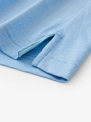 Hem slit detail of BLUE HEATHER Premium Stretch Heather Polo highlighting stitching and finish.
