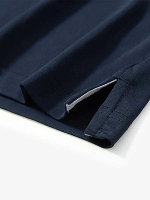 Detail view of the navy long sleeve pique polo, highlighting the hem opening and sleek design.