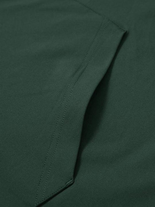 Close-up of single pocket detail on youth long sleeve hoodied with kangaroo pocket in forest green, showing stitching.
