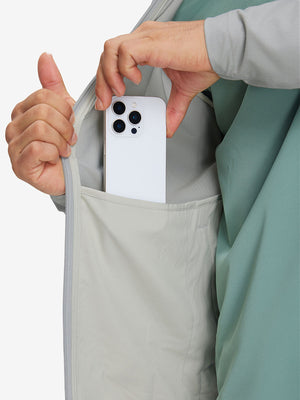 Hand placing iPhone into inner pocket of lightweight water-resistant outerwear jacket in silver grey