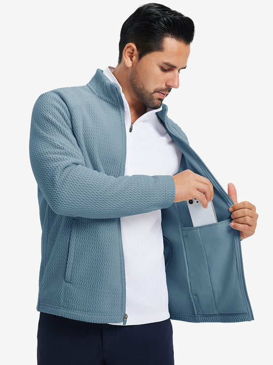 Model showing inner pocket of soft winter fleece jackets in misty blue, fitting an iPhone inside.