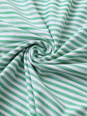 Close-up of green white unique watercolour stripe polo fabric showing soft, blended stripes and smooth texture.