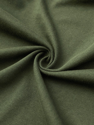 Fabric close-up of olive green cotton blend pique plain shirt, breathable pique fabric texture.