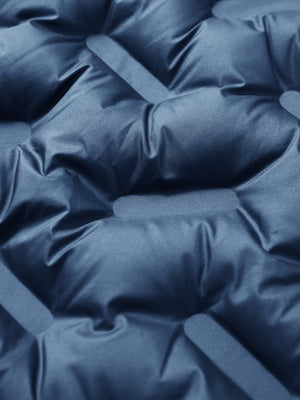 Fabric close-up of boys windproof puffer jacket with pockets, highlighting texture and finish in dark blue.