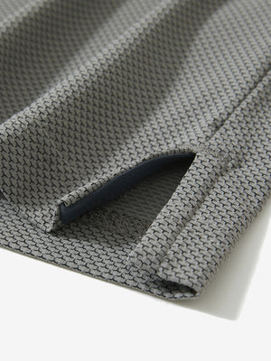 Detail of the side vent hem on the black feather weight jacquard polo shirts, showing the split design feature