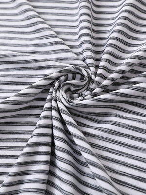 Close-up of black white unique watercolour stripe polo fabric showing soft, blended stripes and smooth texture.