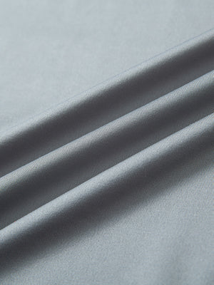 Close-up of light grey long sleeve solid jersey polo fabric texture showing soft knit and smooth finish details.