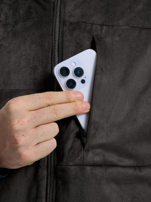 Close-up view of dark brown classic micro suede leather puffer vest exterior center pocket detail