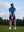 Model in cobalt your favorite jacquard polo preparing to tee off, full-body shot