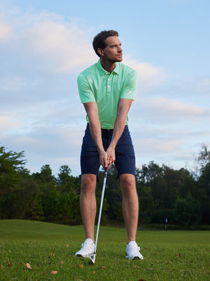 Model in light green your favorite jacquard polo preparing to tee off, full-body shot
