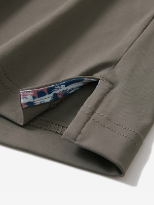 Detail of the side vent hem on the light brown everyday classic solid polo, showing the split hem feature