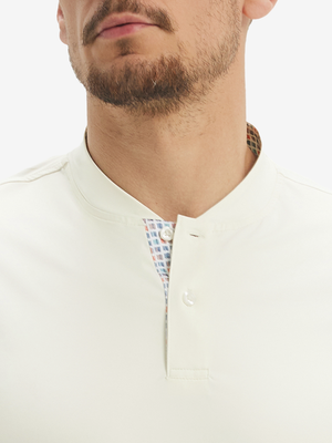 Close-up of model in cream moisture-wicking short sleeve henley shirt, nose to chest front view.