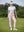 Woman wearing Women's Ultra-stretch Quick Dry Sweatpants with Ankle Zips in pale pink, holding golf club on course